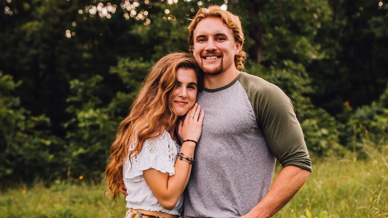 Kevin and Riley Root standing together in the woods near their Missouri studio