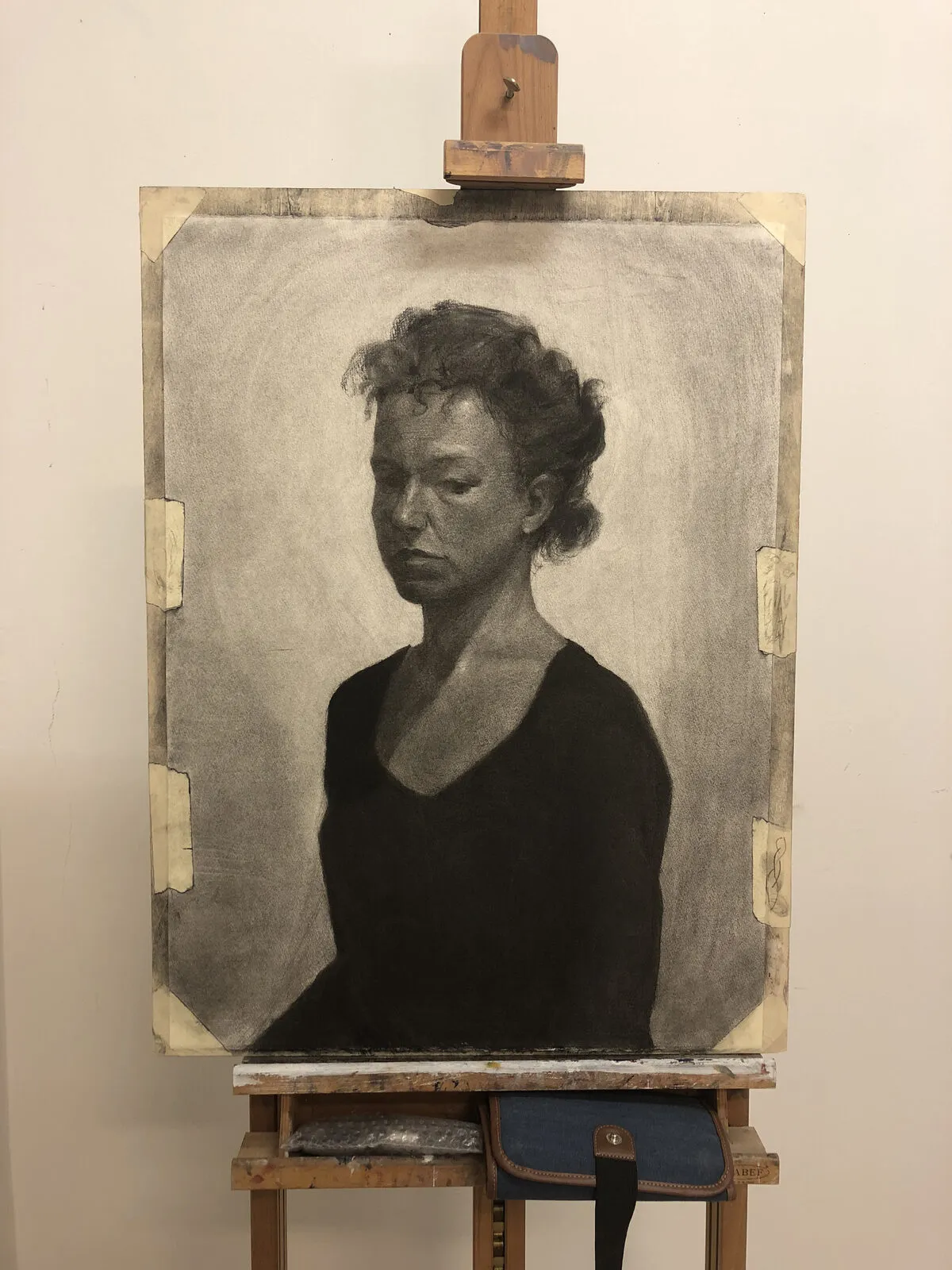 Charcoal portrait drawing on an easel