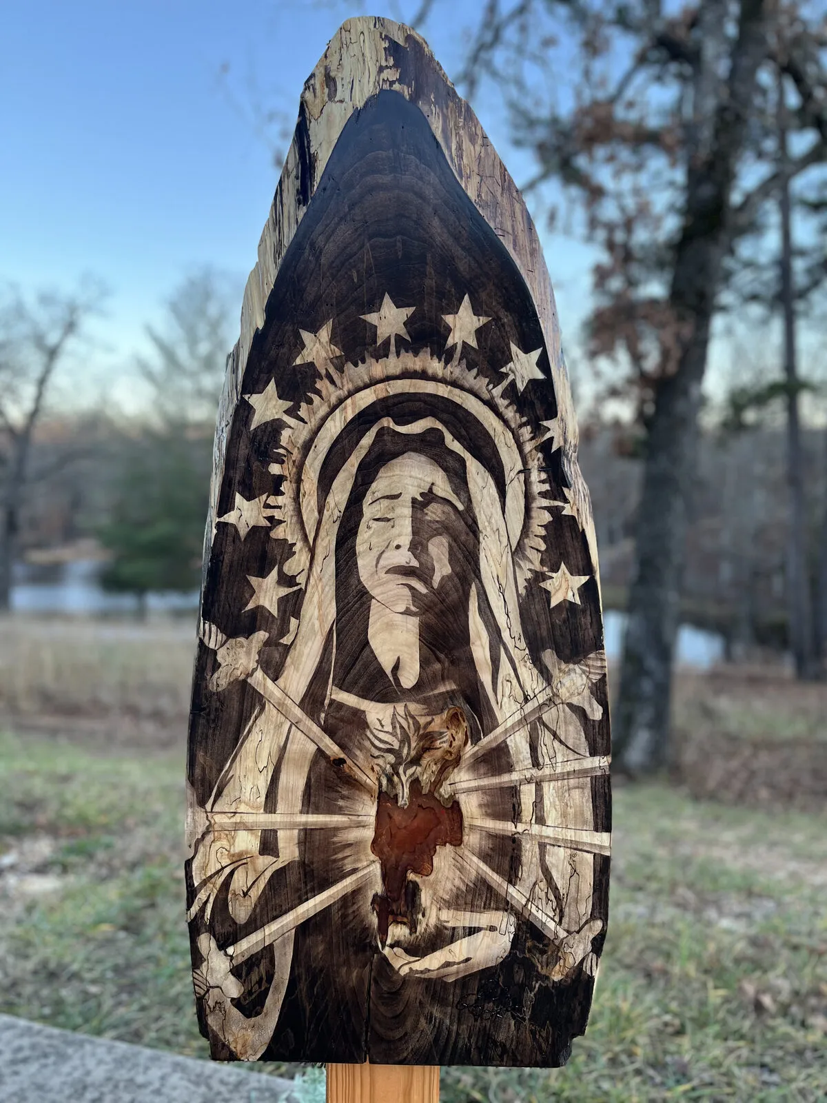 Our Lady of Sorrows with seven swords stained into a wood panel